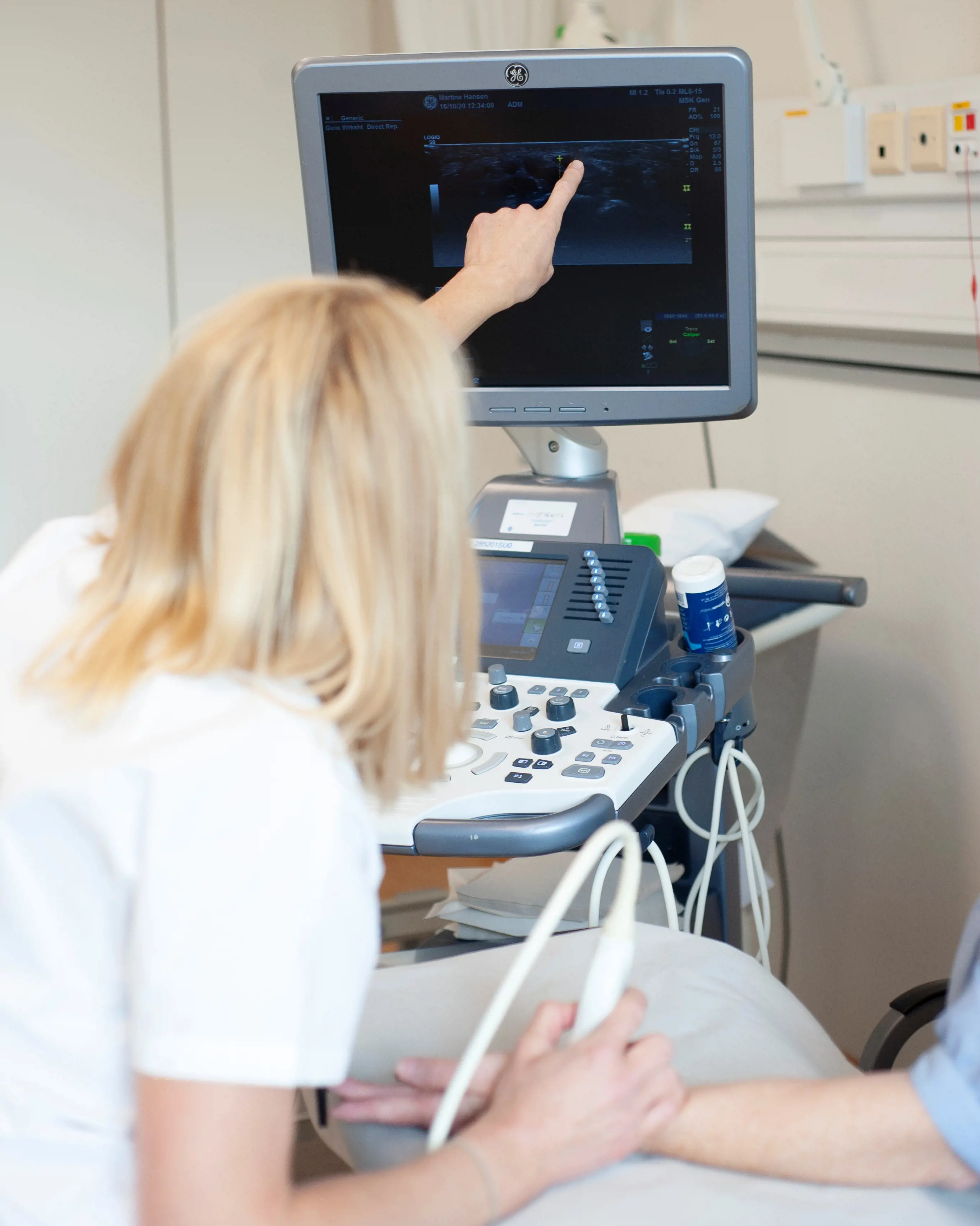 Revmatolog som viser hva hun der på skjermen under en ultralydundersøkelse.